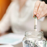 A jar with rolled banknotes on the table